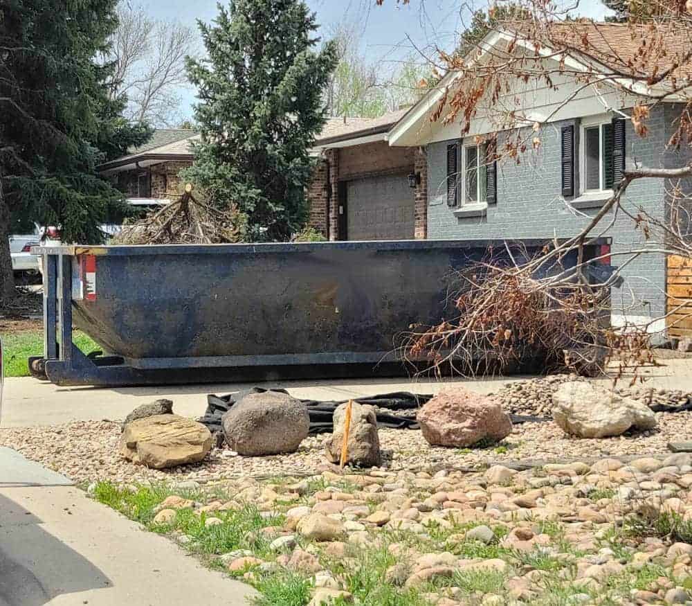 blue 12 yard dumpster in a driveway