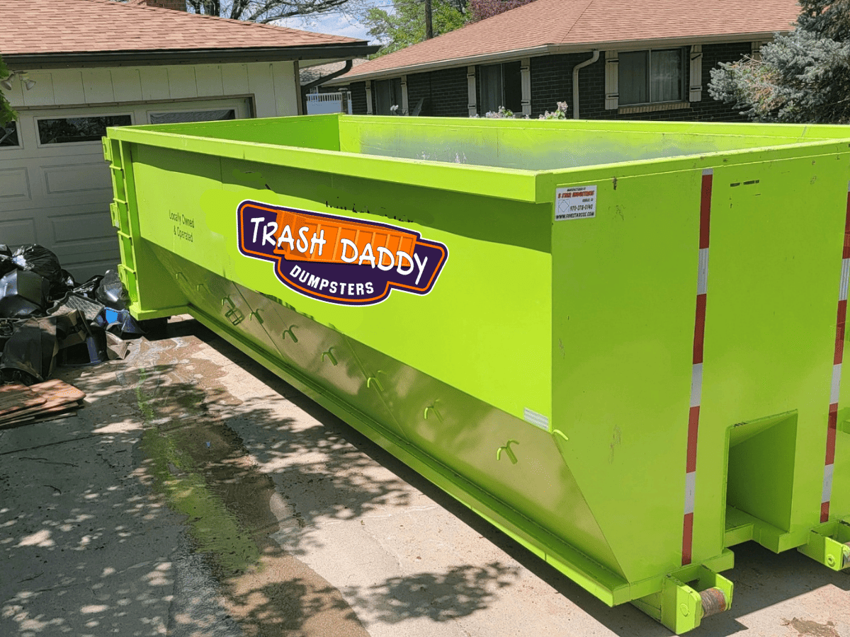 green 30 yard dumpster in a driveway in fort collins