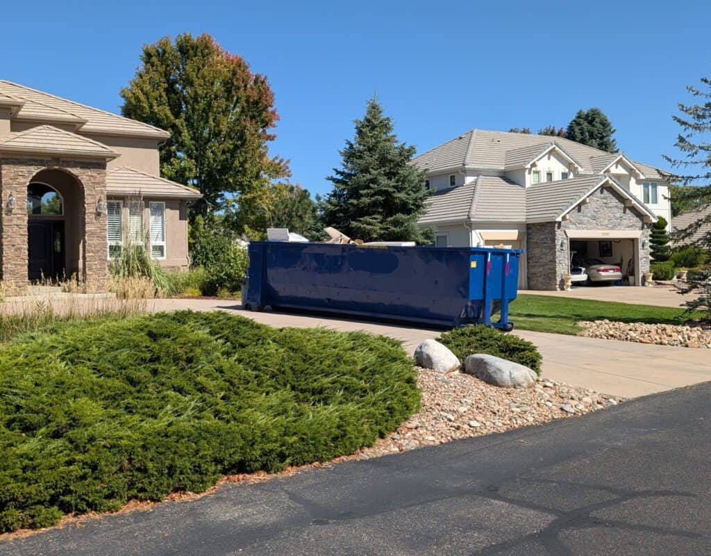 blue 30 yard dumpster in a driveway