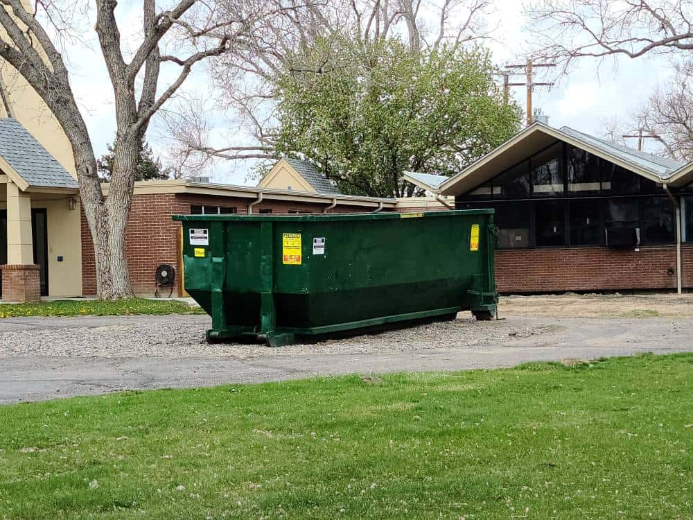 green 20 yard dumpster in driveway