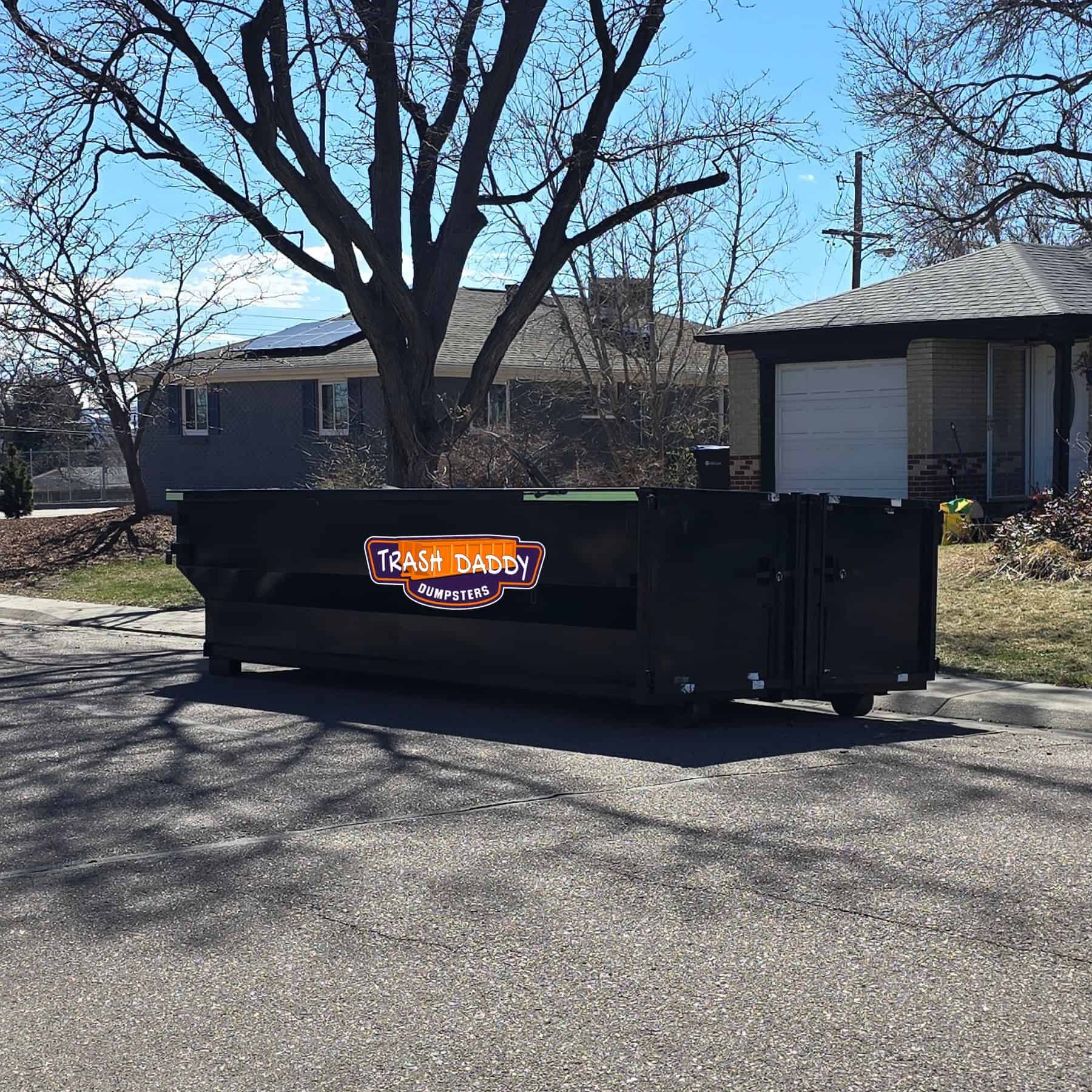 black 12 yard dumpster on street