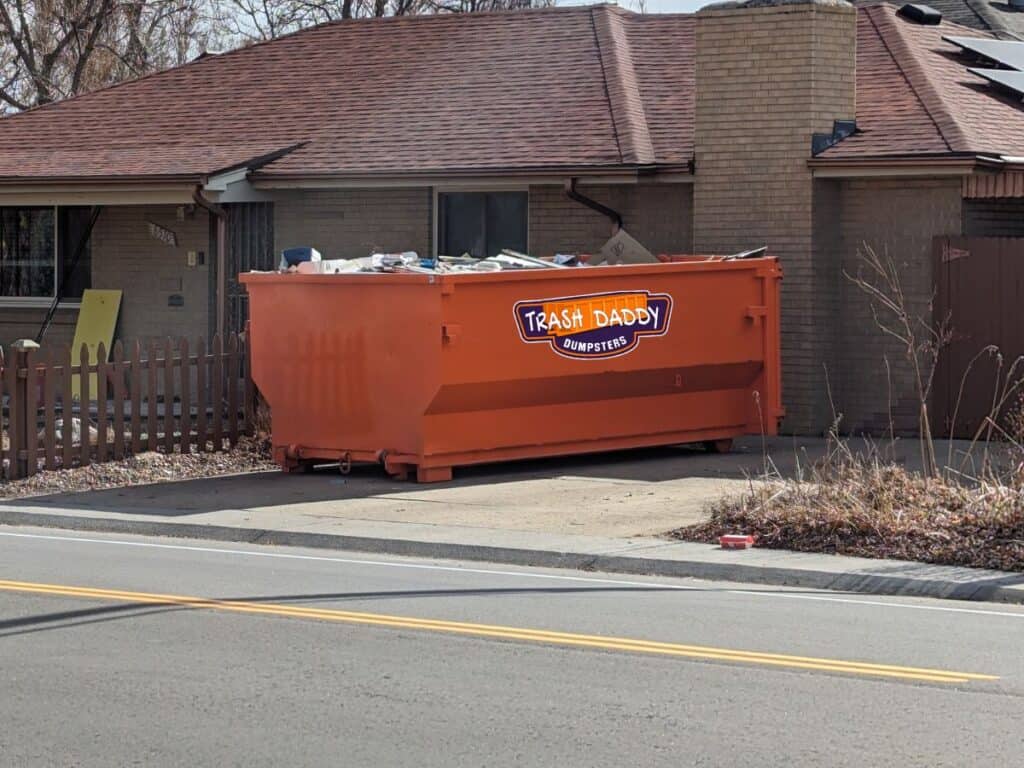 orange 10 yard dumpster rental in a driveway