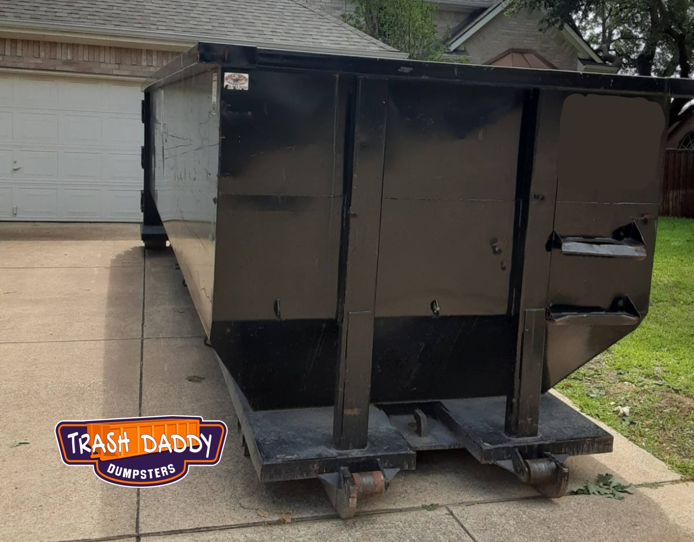 black 20 yard dumpster in a driveway