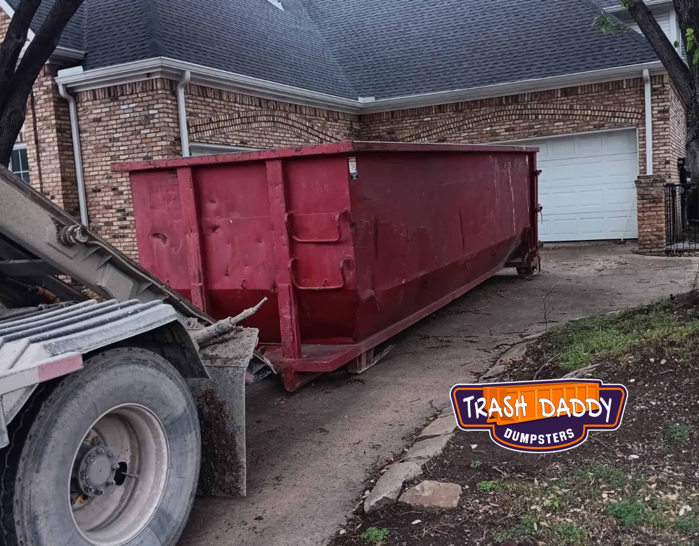 red 30 yard dumpster in a driveway
