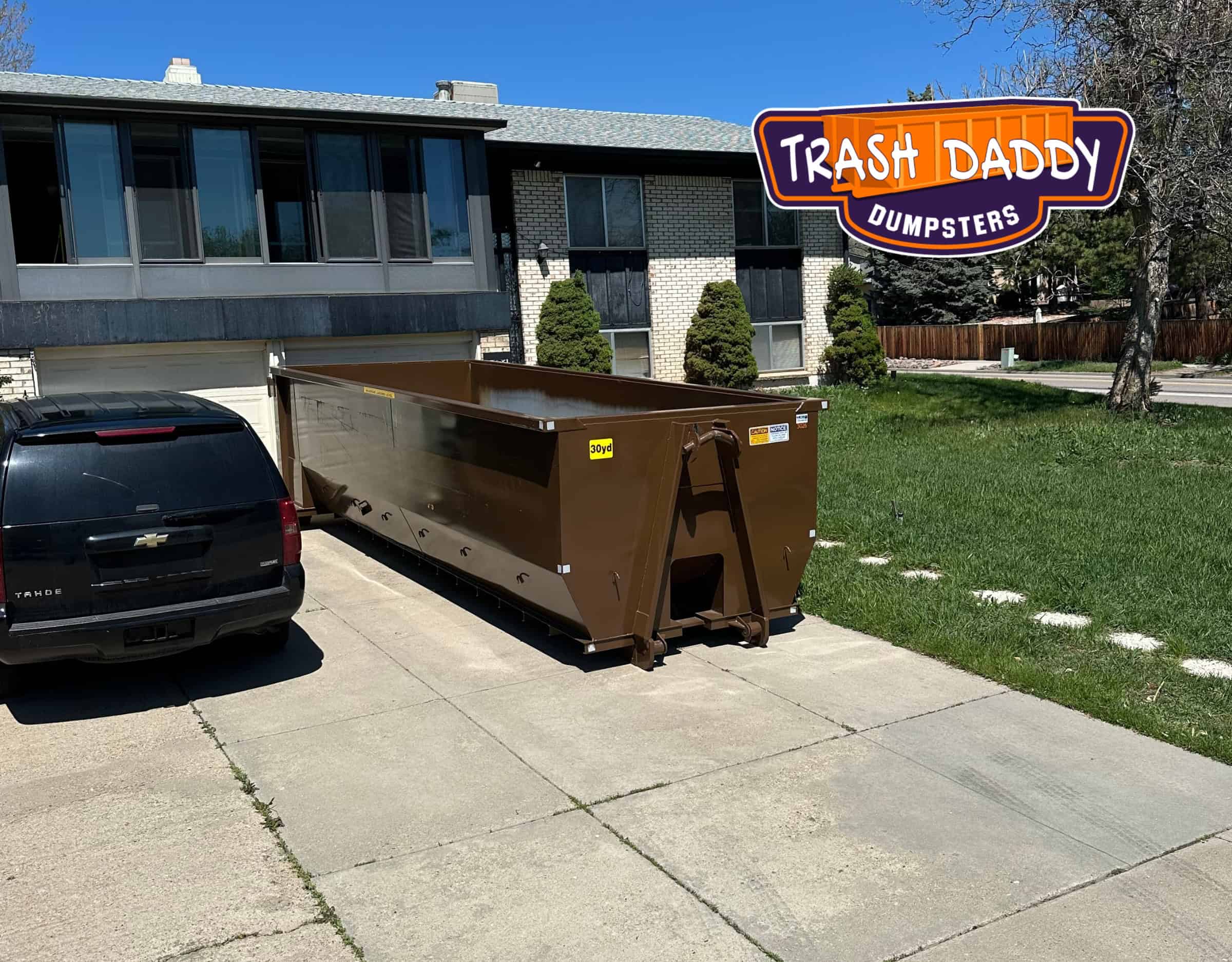 brown 30 yard dumpster in driveway