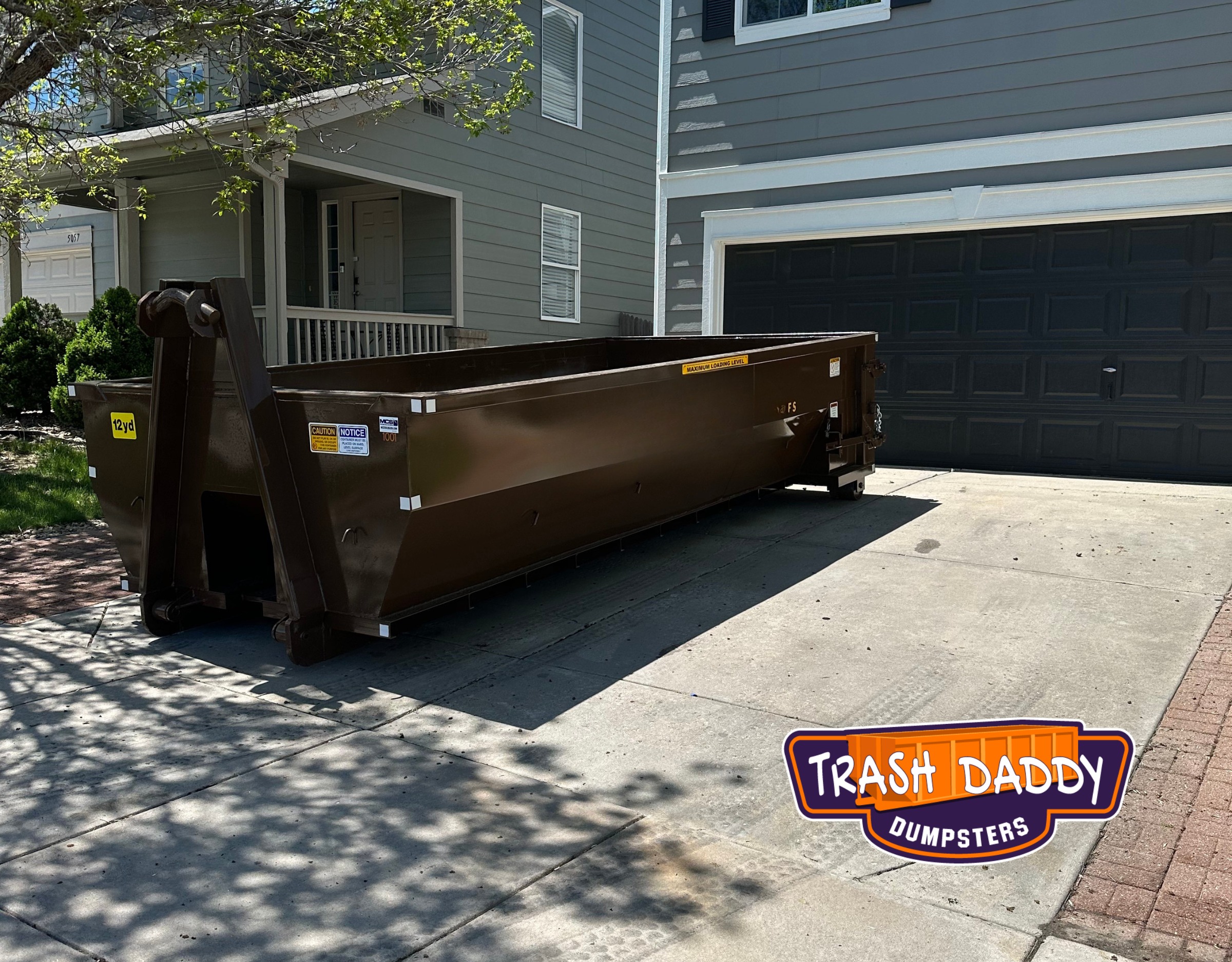 brown 12 yard dumpster in a driveway