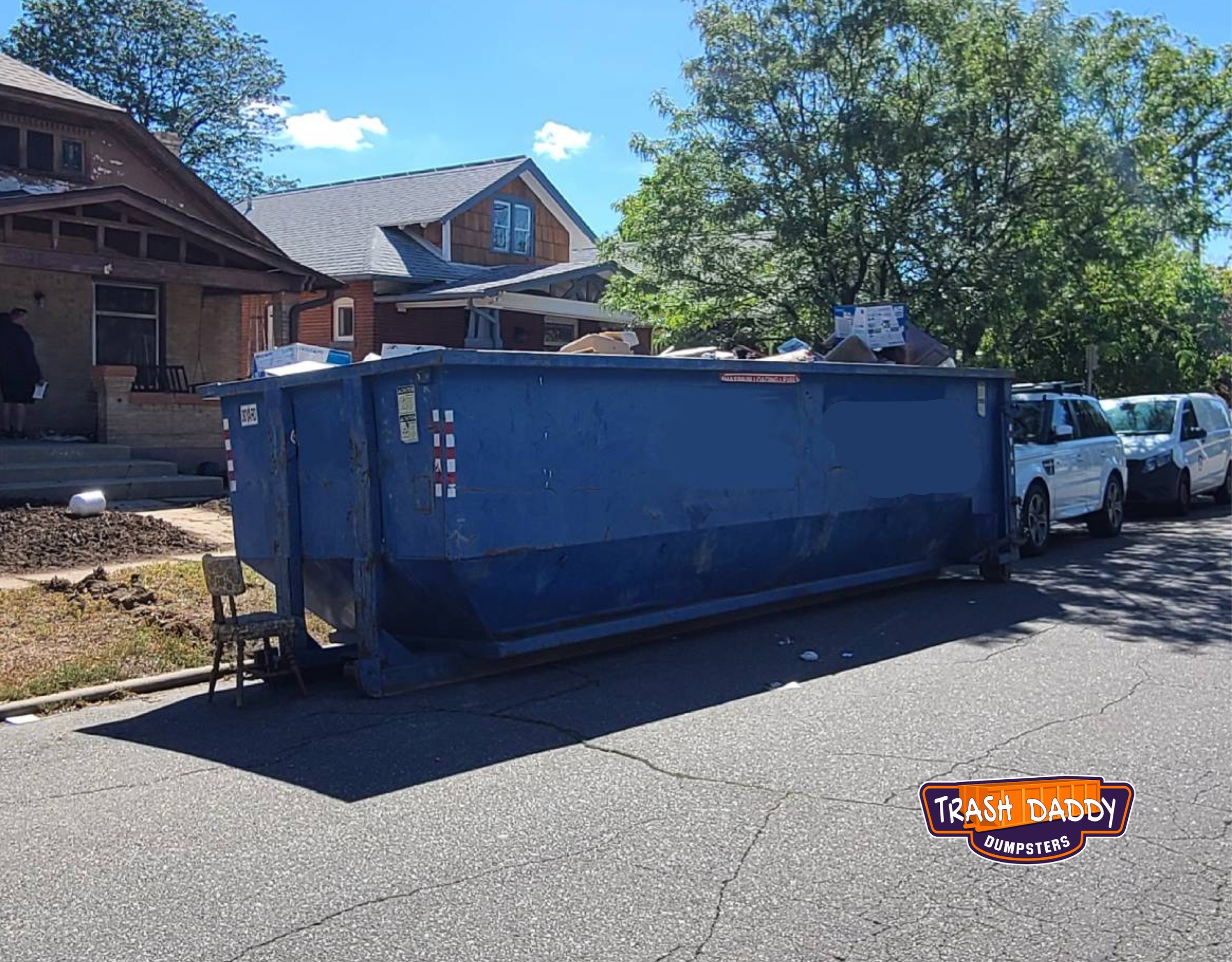 blue 30 yard dumpster for a home cleanout placed in the street