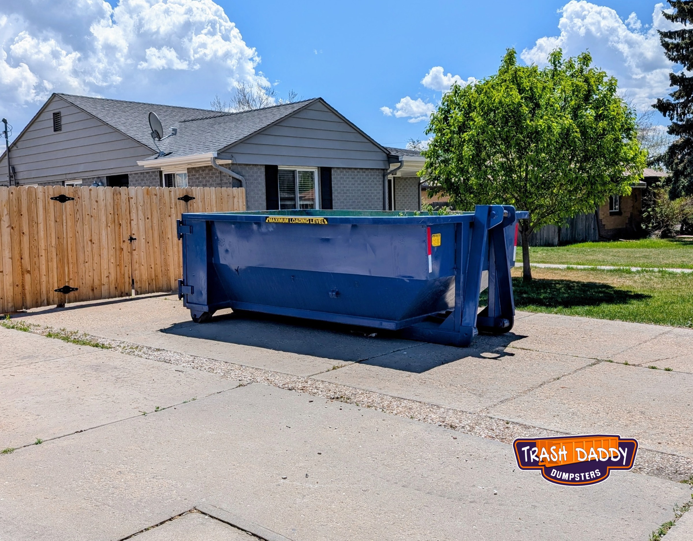 Blue 15 yard dumpster in a driveway