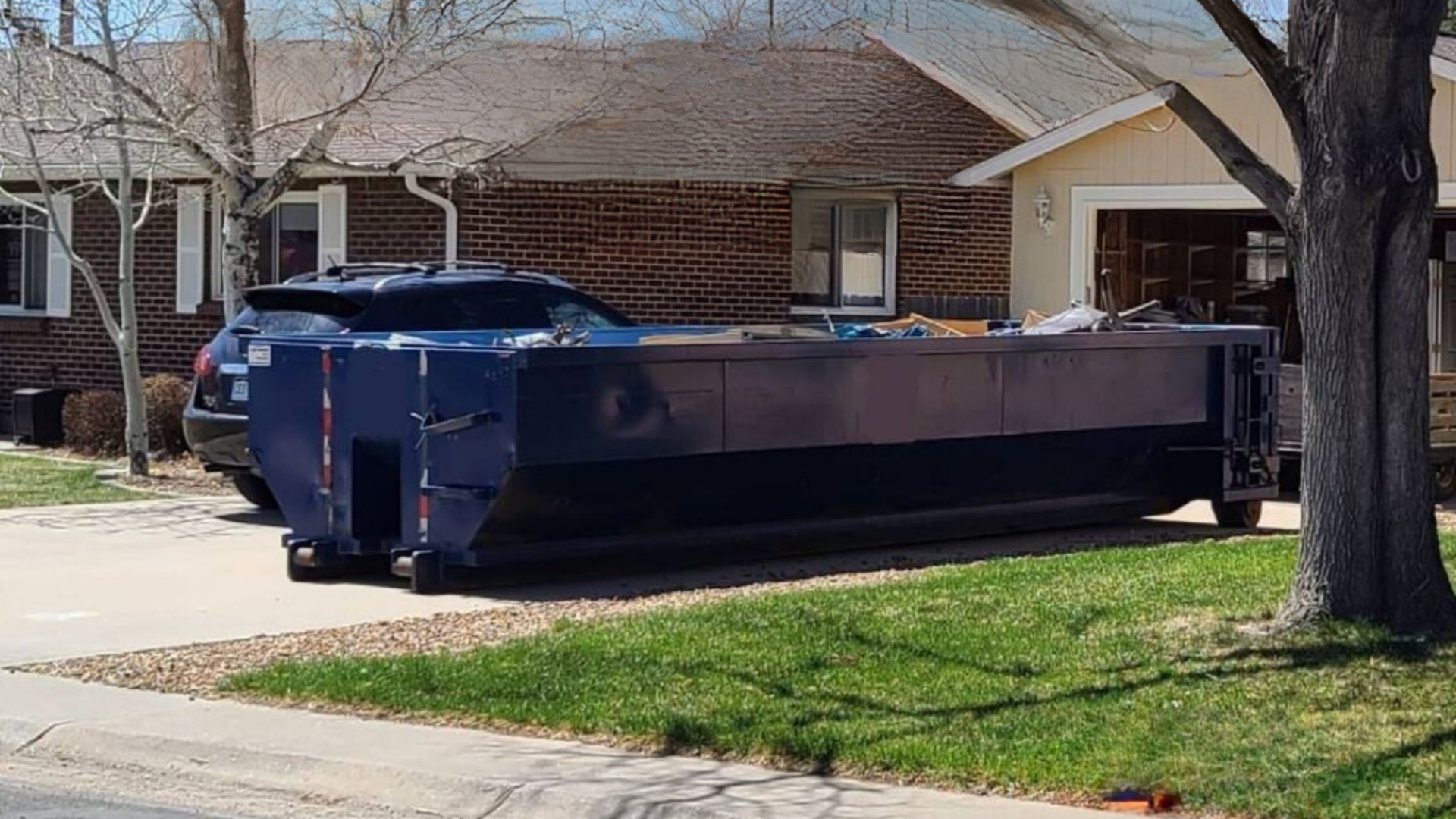 blue 20 yard roll off dumpster in a driveway